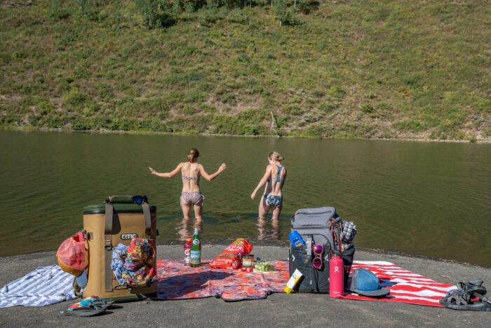 two women walking into a lake 