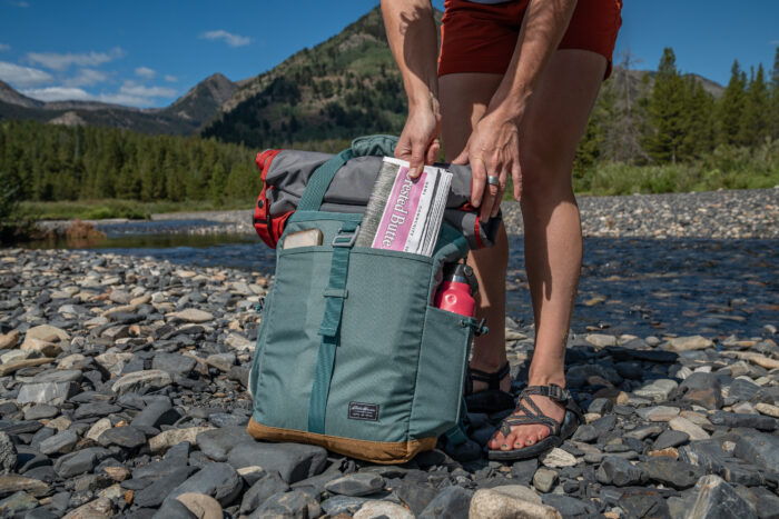 person pulling newspaper out of pack 