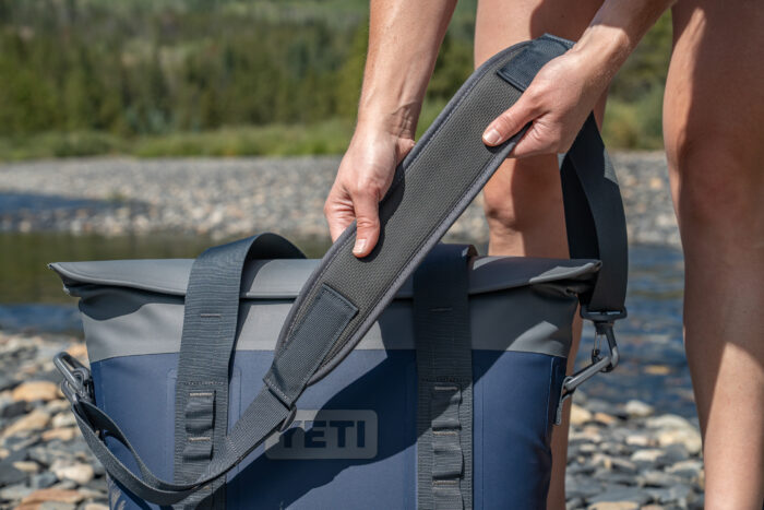 woman holding interior shoulder pad of tote bag 