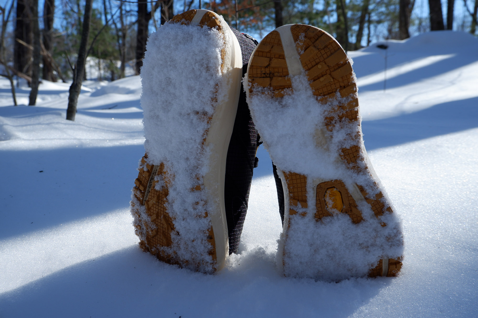 Bottom of Tracksmith Eliot NDO shoes showing snow packed into the tread