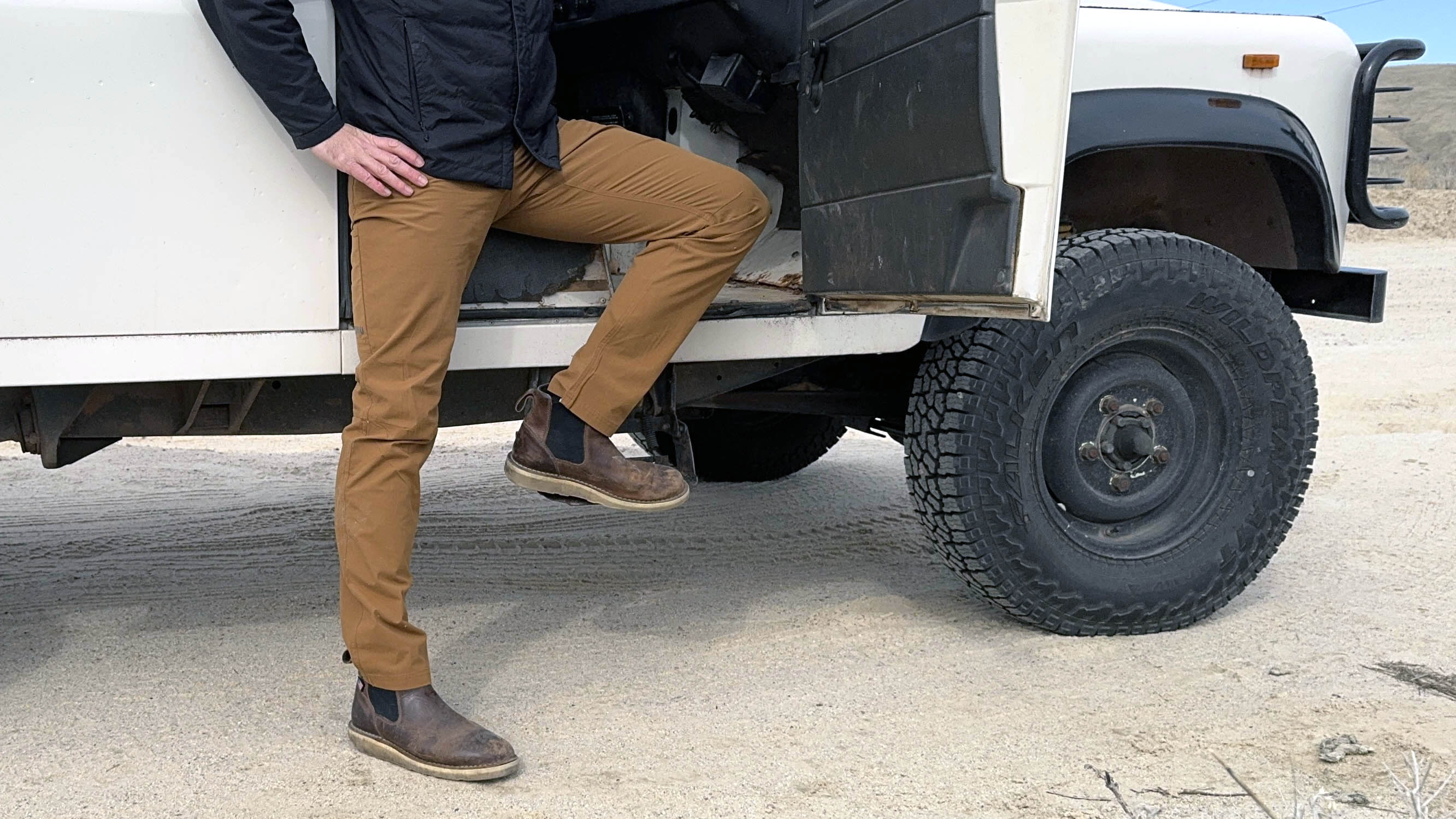 the author wearing travel pants and stepping out of his vintage landcruiser
