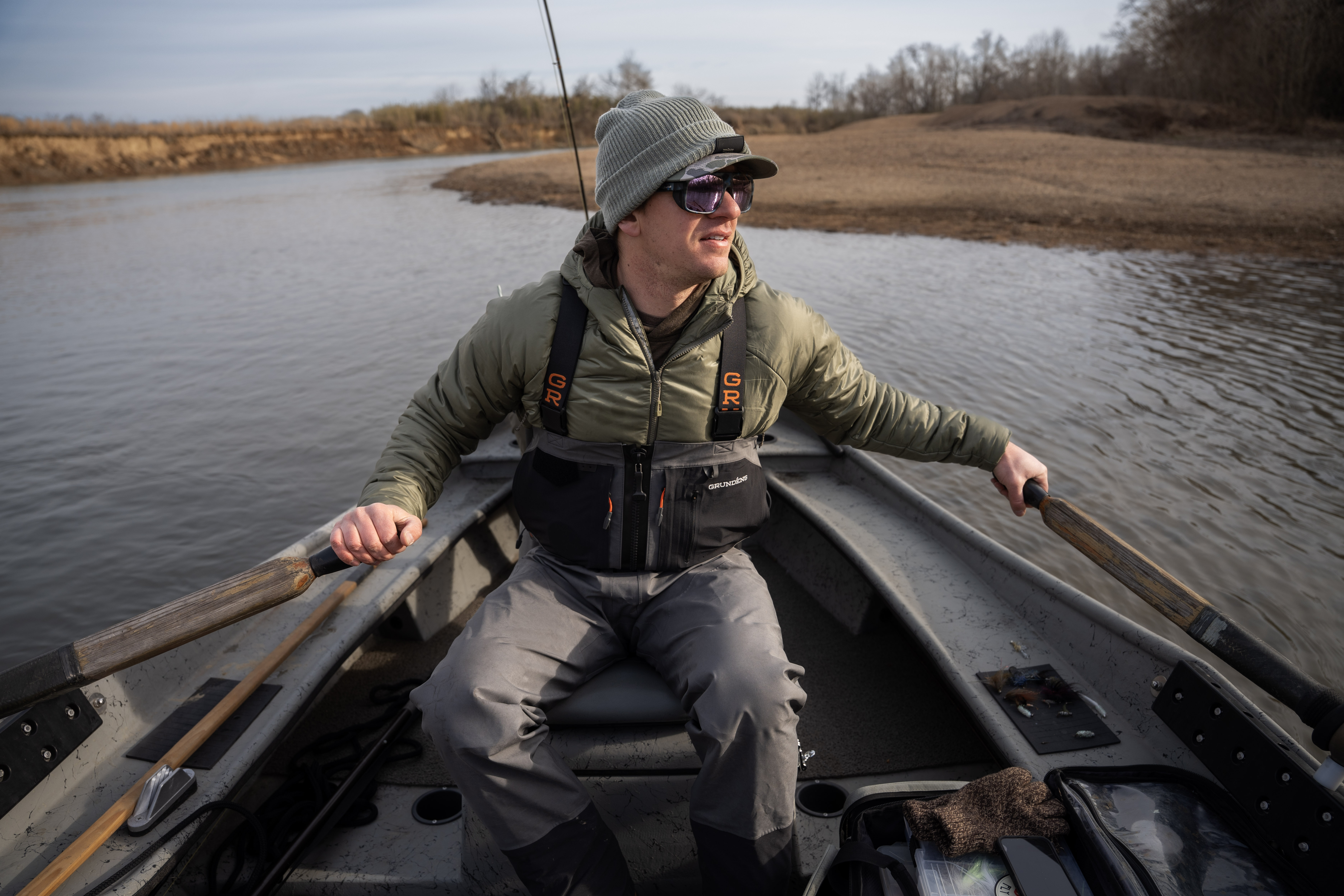 An angler rowing a driftboat.