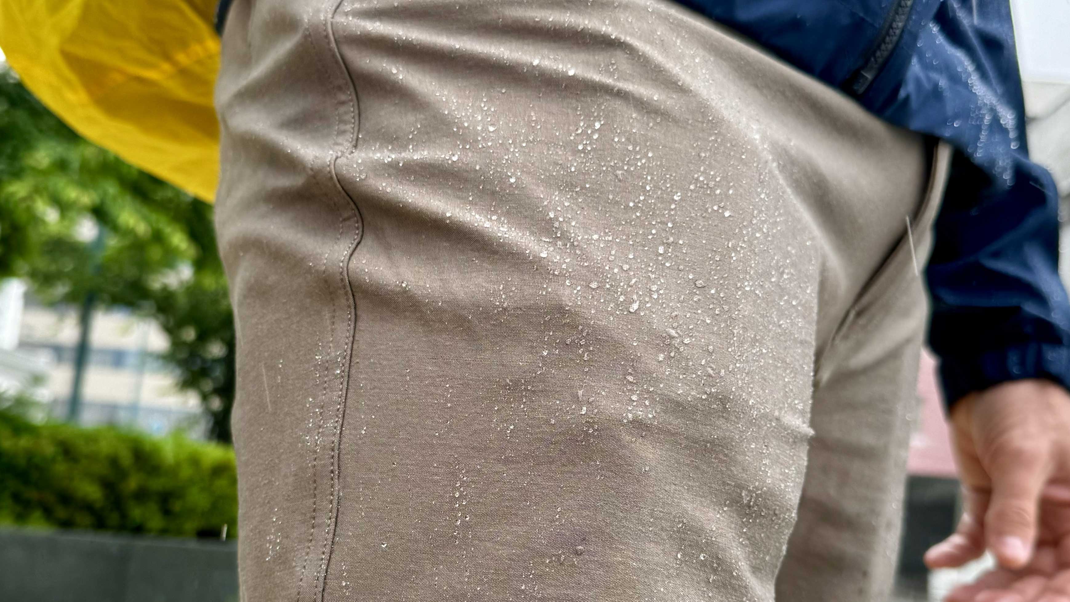 a tight image of travel pants beading up water from a DWR finish
