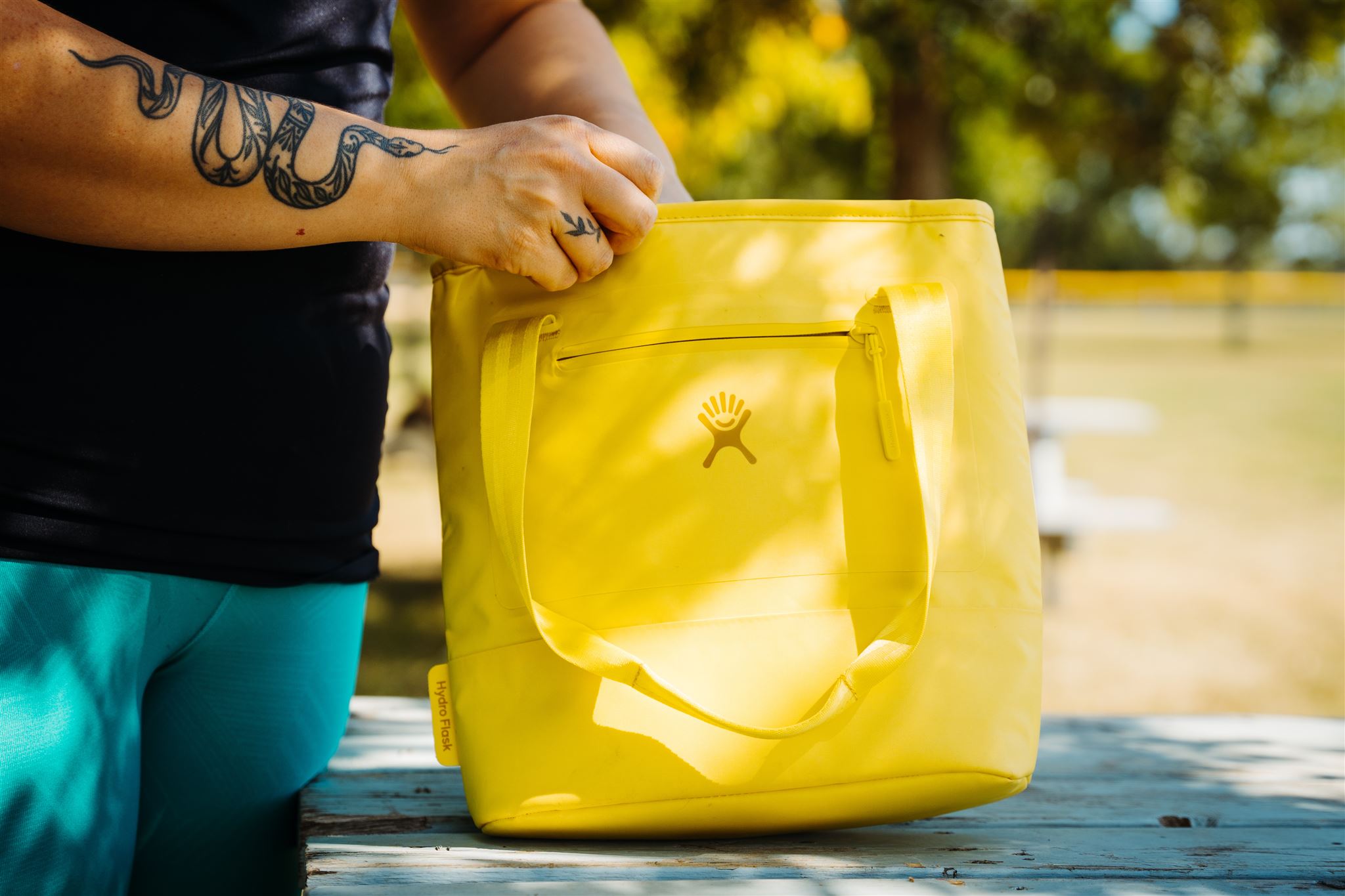 The Hydro Flask 20L Insulated Tote in yellow on picnic bench