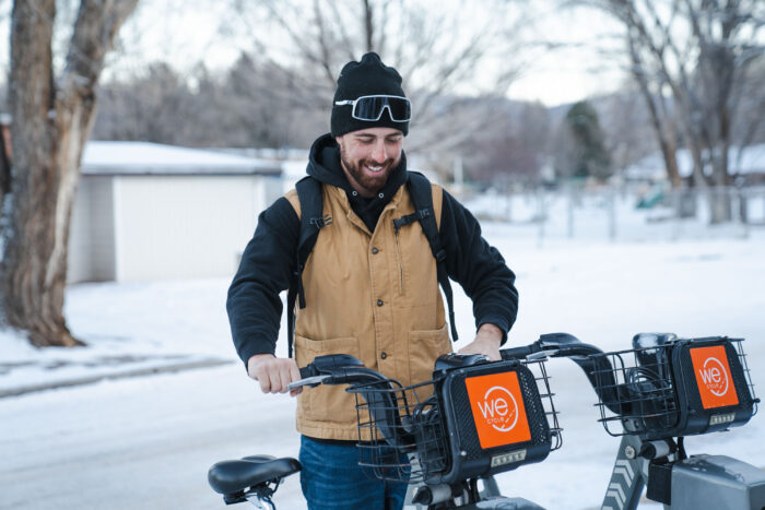 a gearjunkie tester wearing a laptop pack handles an e-bike in the snow
