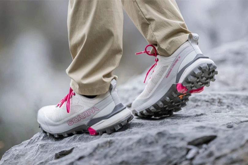 close-up shot of person traversing rocks in gray hiking shoes