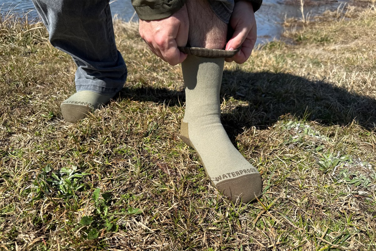 Mountain socks being pulled up for a snug fit outdoors