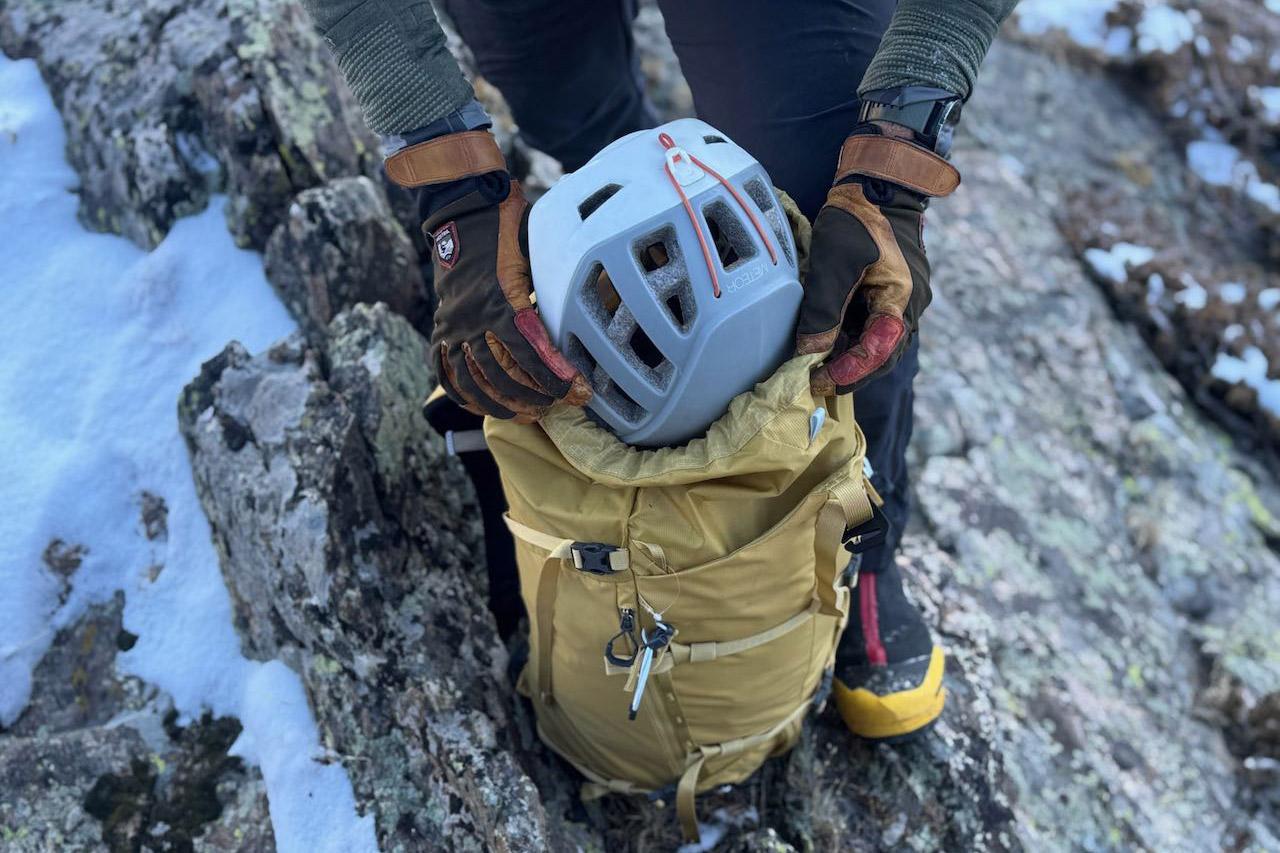 Helmet being placed inside the Gregory Alpinisto 30 pack