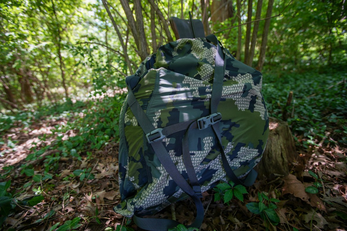 A decoy bag loaded with decoys leaned up against brush.