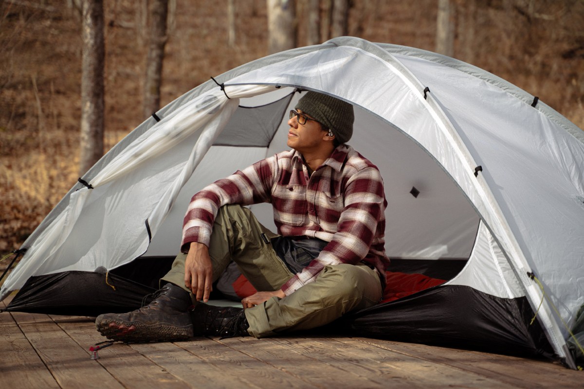 Tarptent dome with person seated inside open doorway on platform