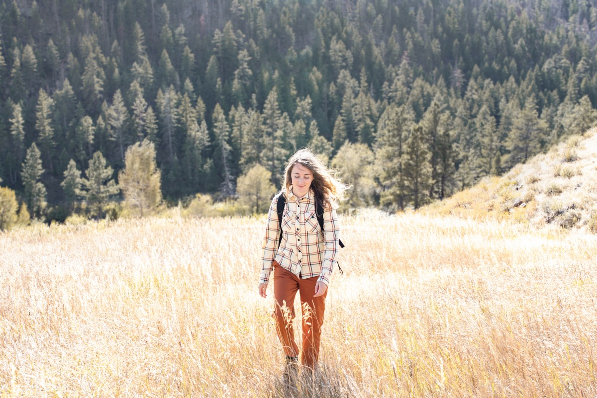 woman wearing Topo Designs Mountain Flannel walking through field