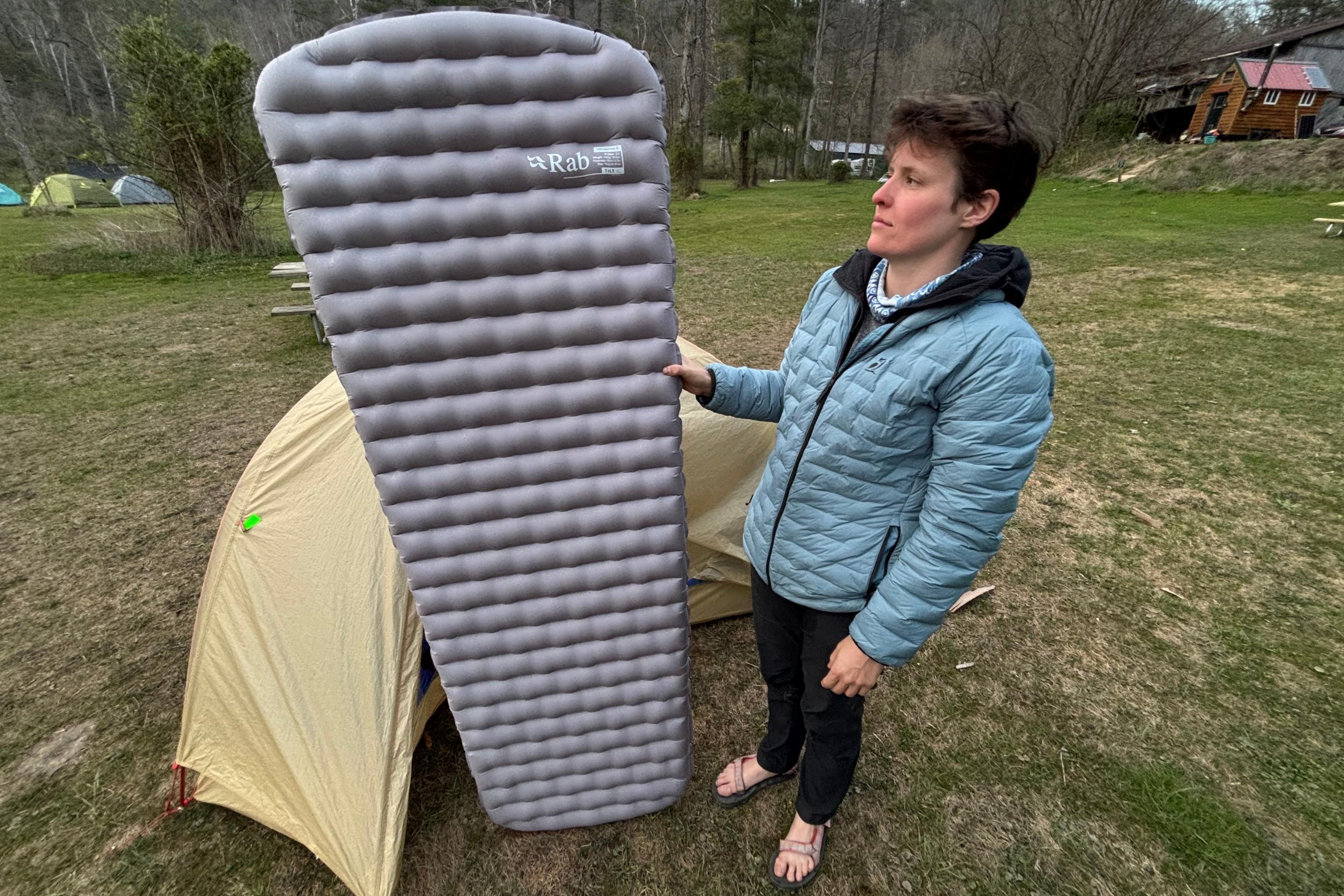 person stands next to sleeping pad