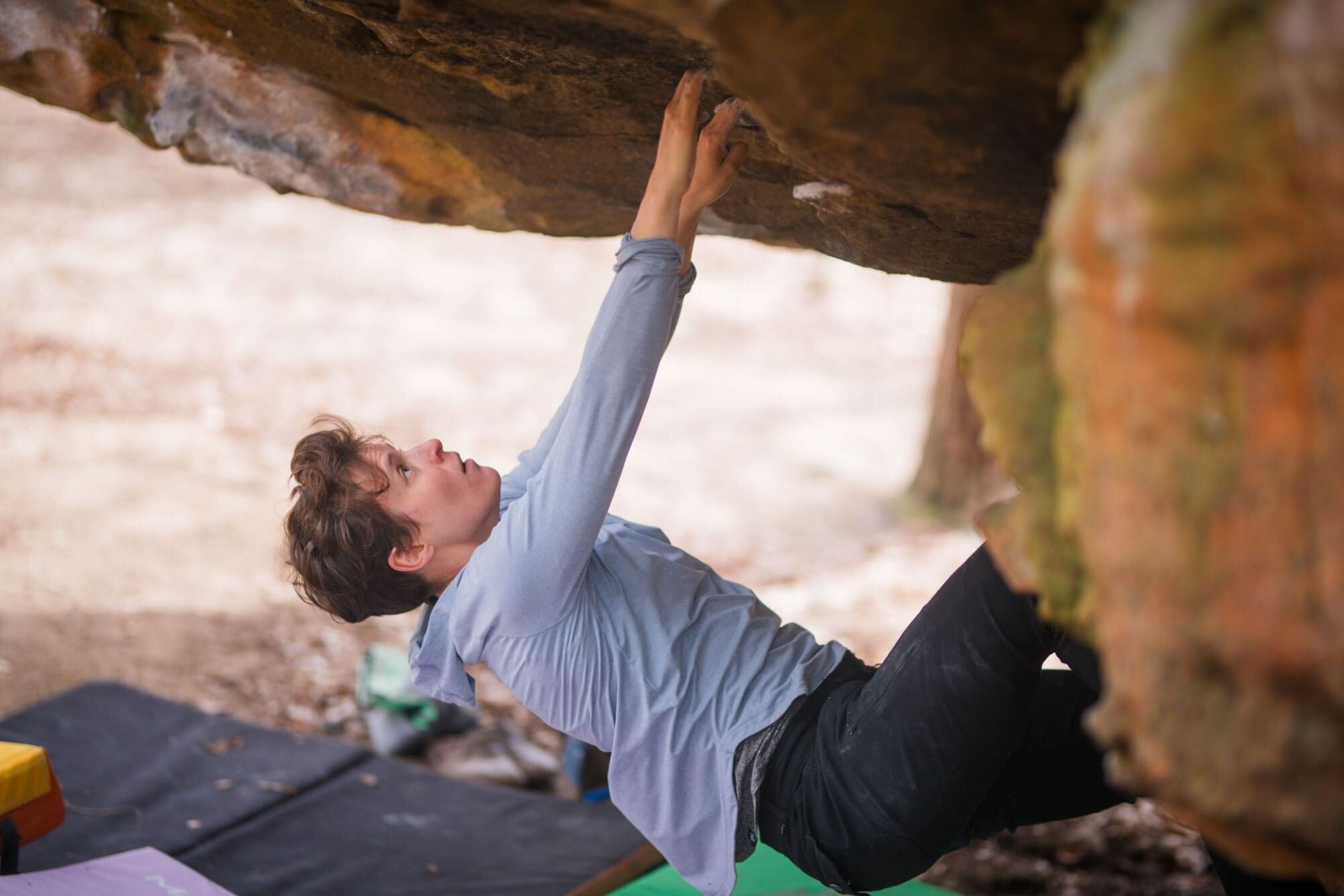 woman climbing a boulder