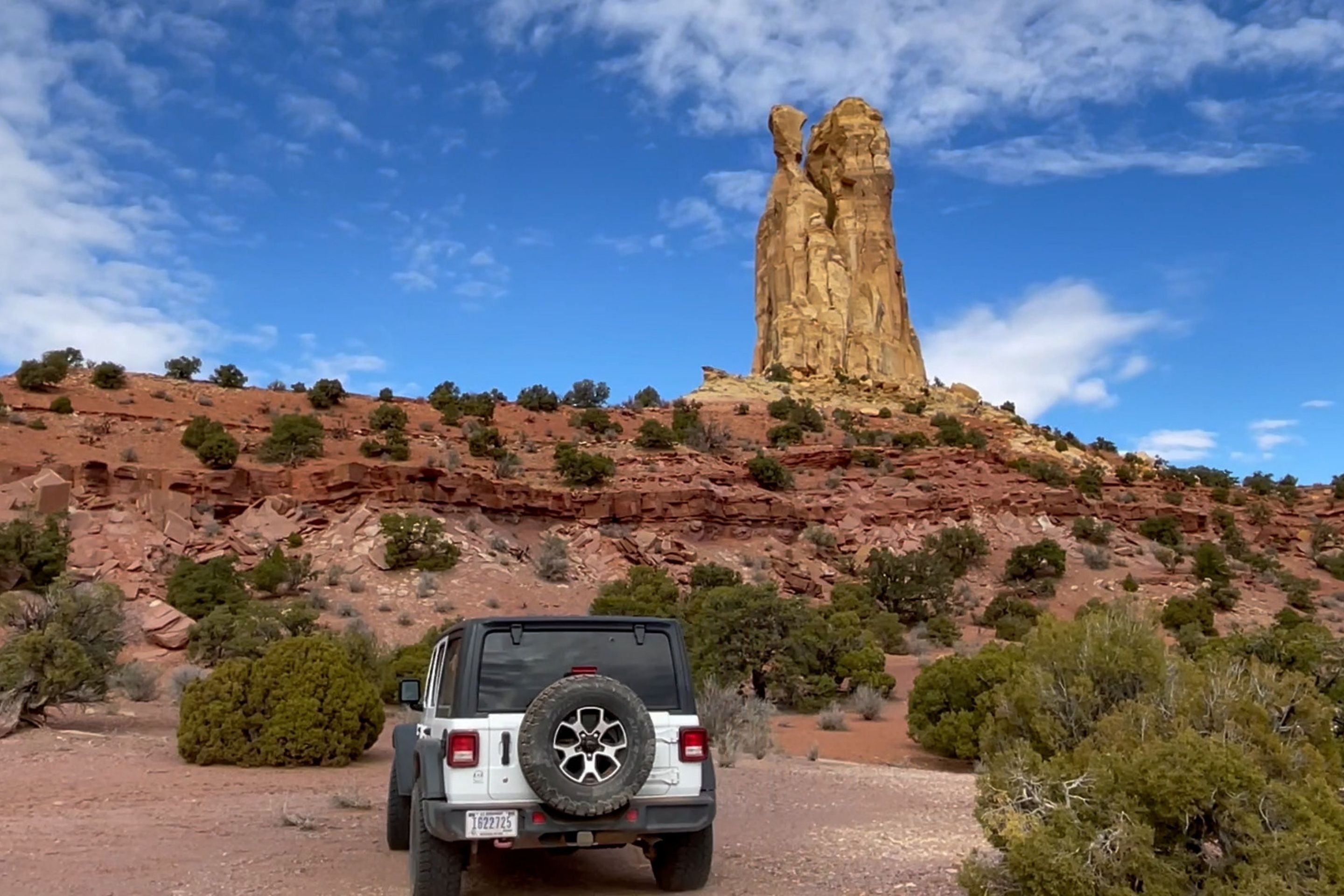 car in nature in front of rocky spire