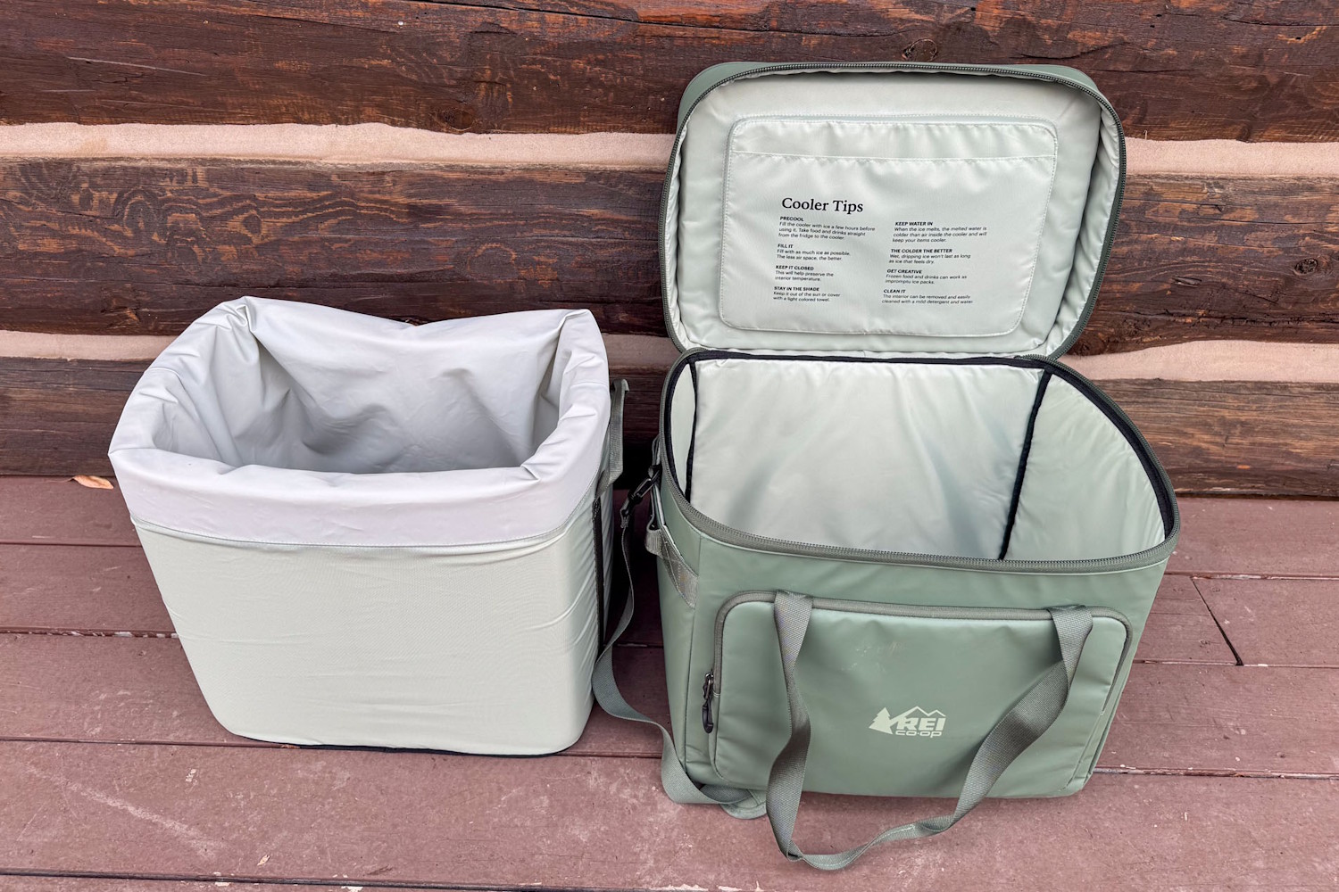 The grey waterproof foam liner of the REI Trail Gate cooler removed and sitting next to the empty green outer shell.