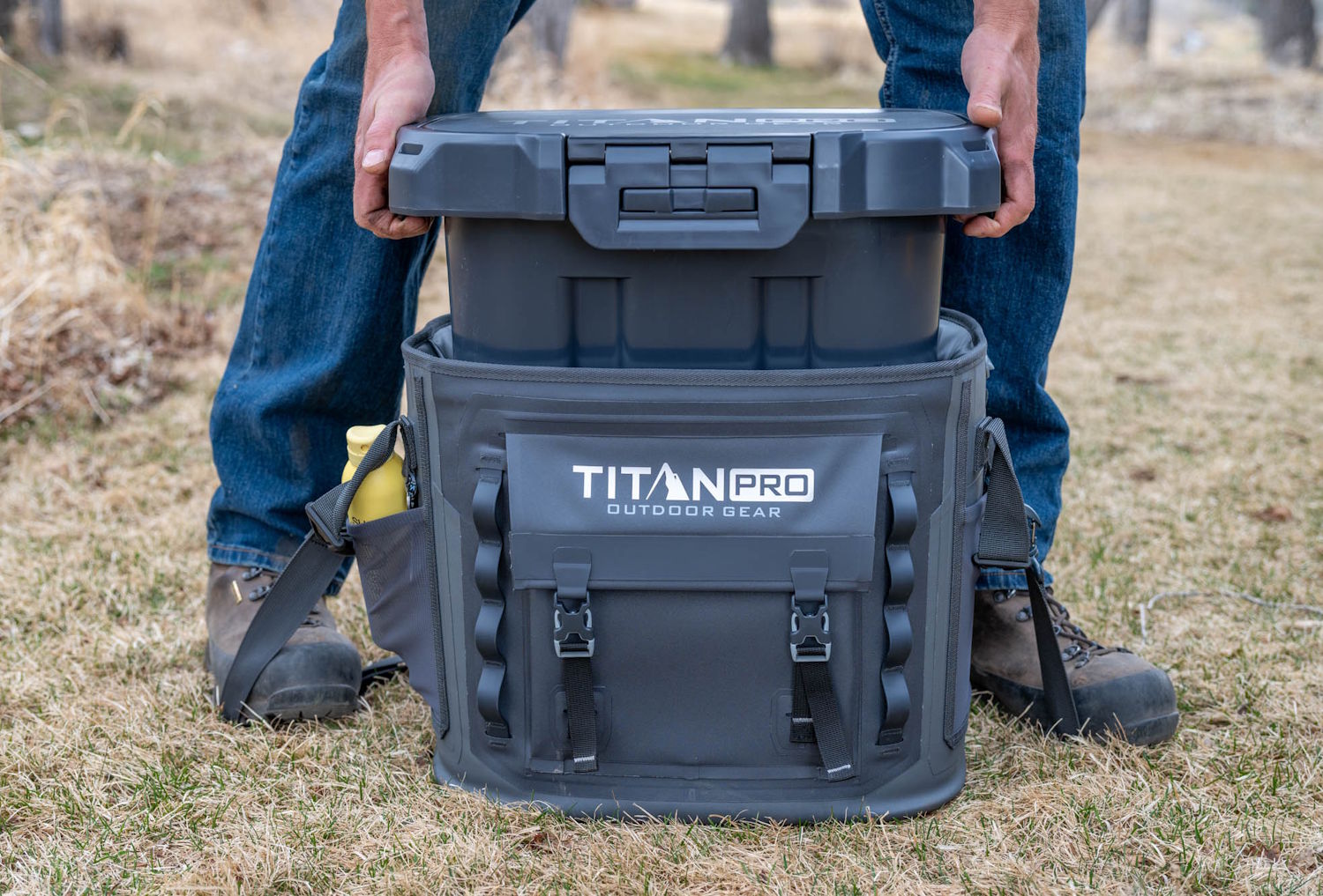 Man placing a rugged Titan PRO outdoor cooler into a soft insulated bag.