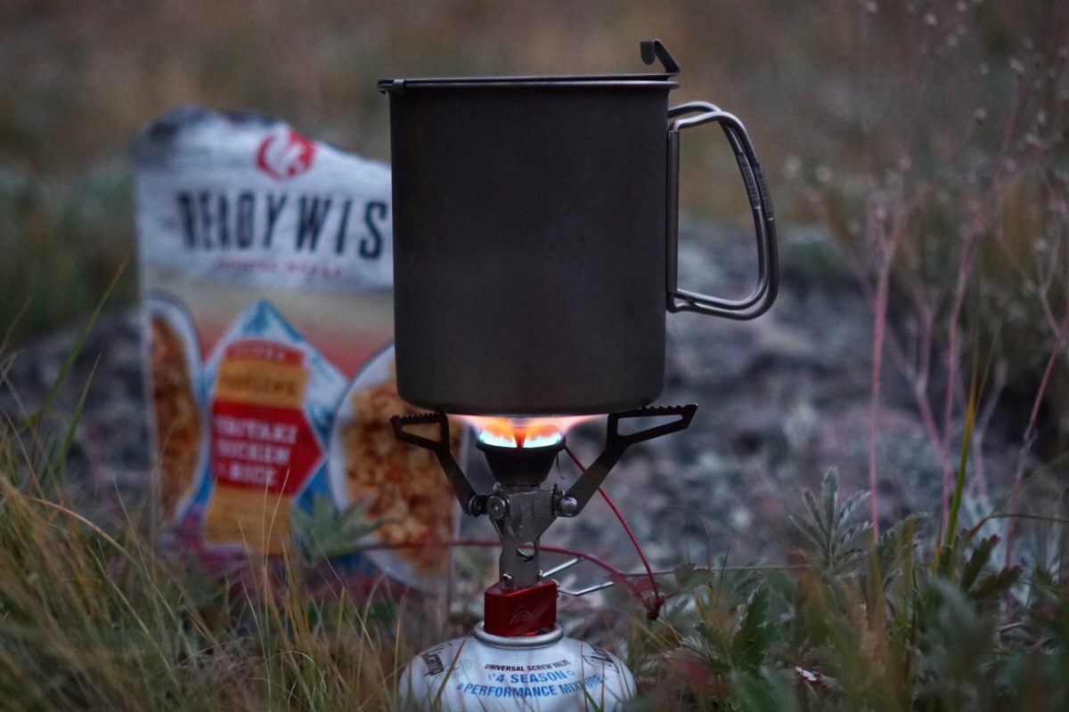 An MSR backpacking stove heating up a meal