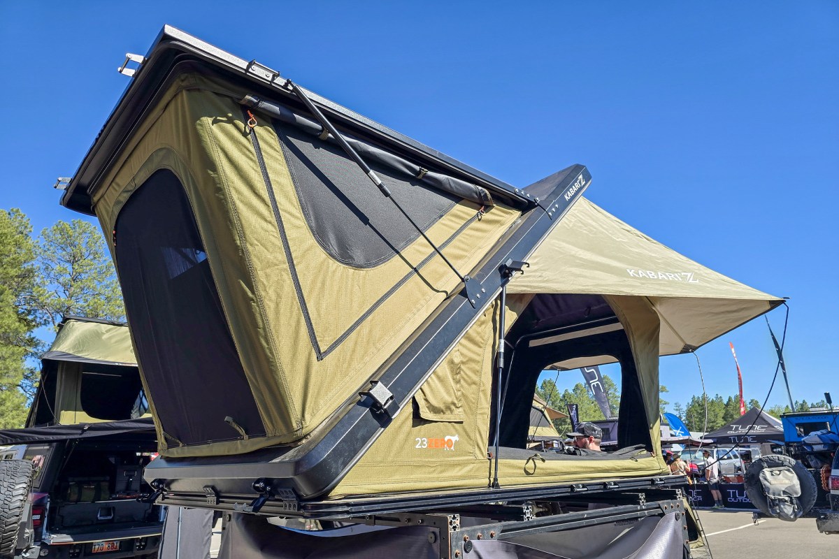 23Zero Kabari Z aluminum Z-lift hard shell roof tent set up with an awning at Overland Expo West