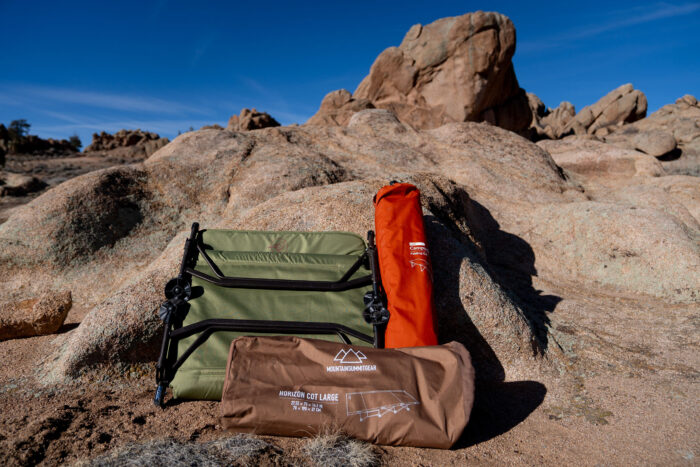 three different packed camping cots side-by-side to show different storage methods and sizes