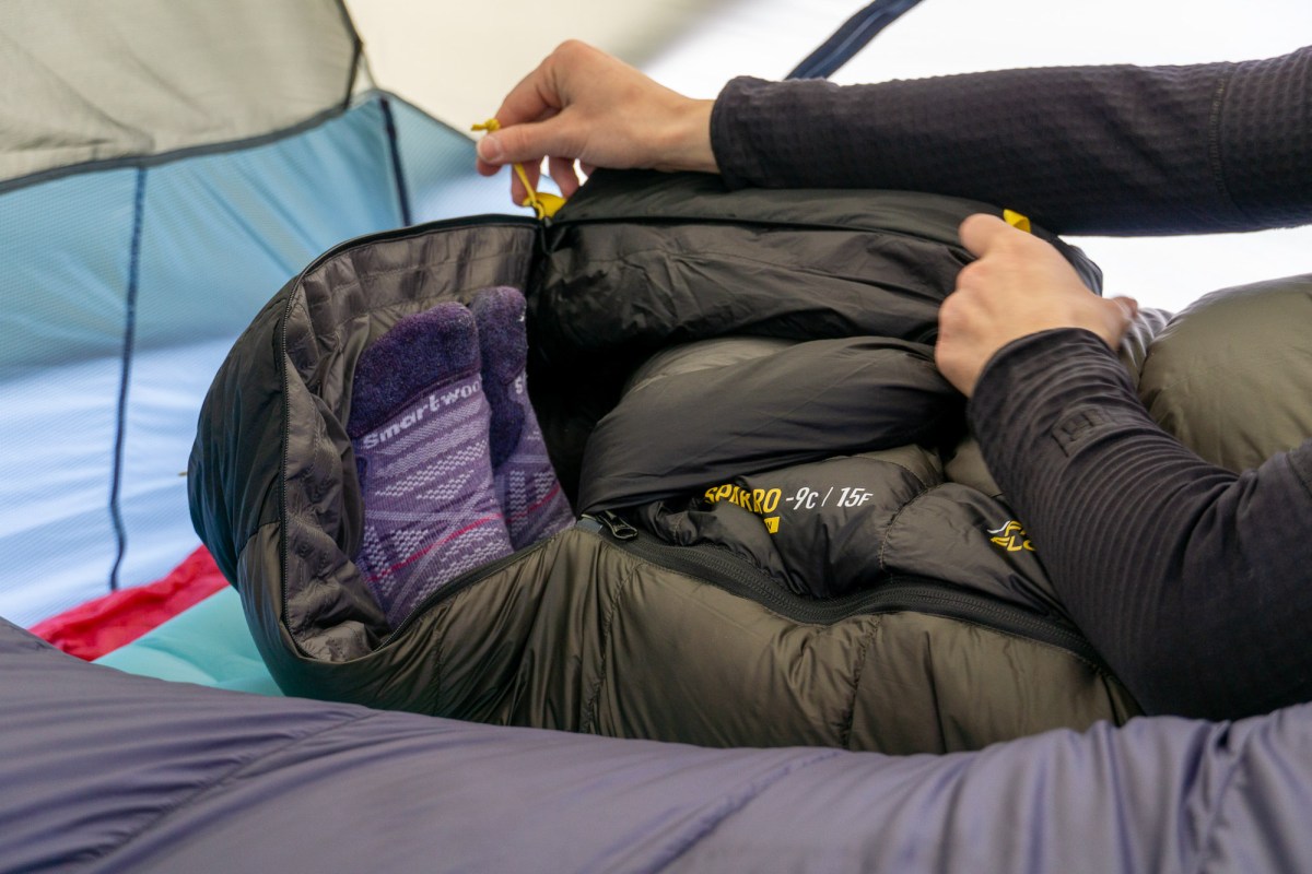 a gearjunkie tester unzipping the footbox of her sea to summit spark pro sleeping bag to get some ventilation