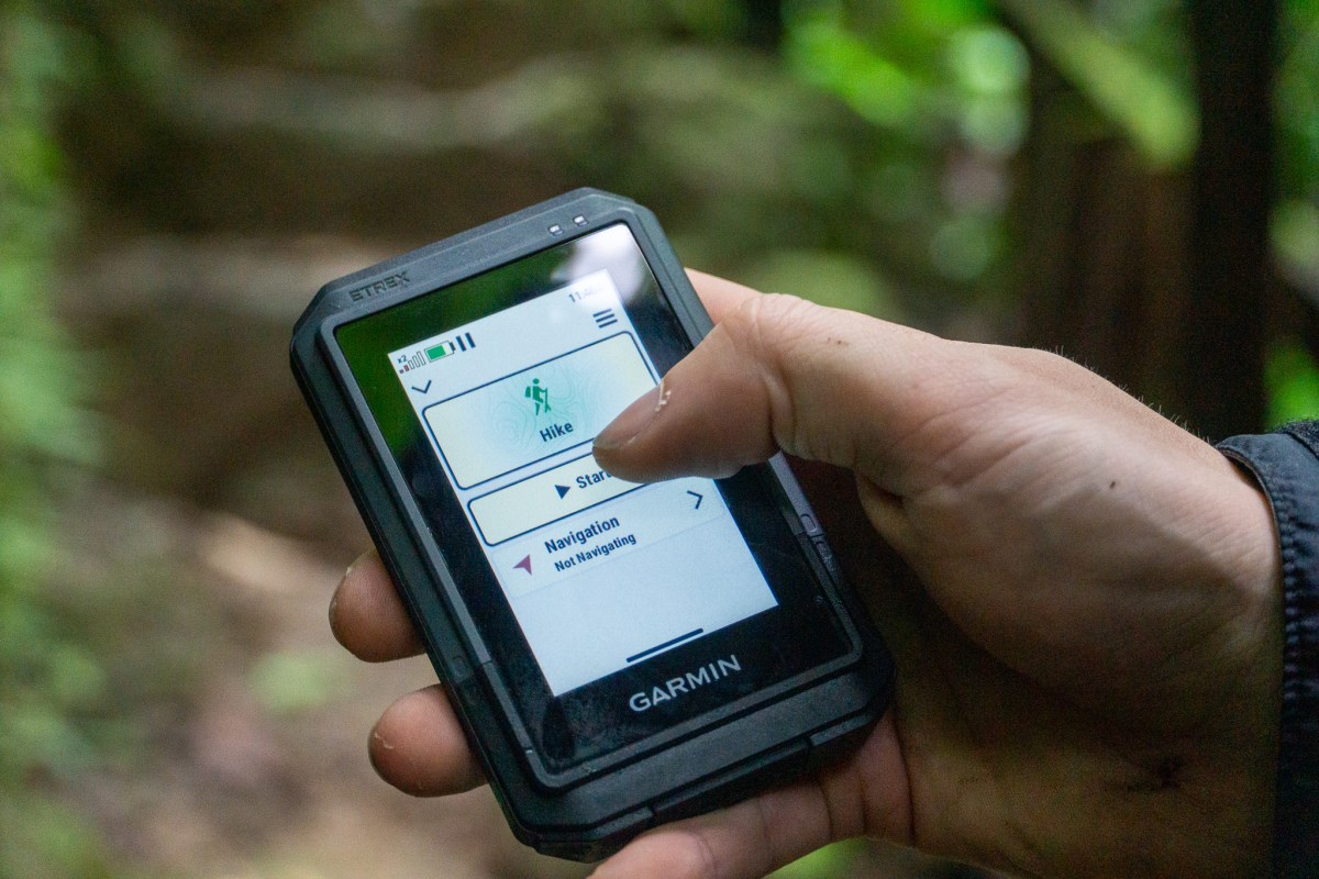 a gearjunie tester holds the garmin etrex touch unit while hiking in costa rica