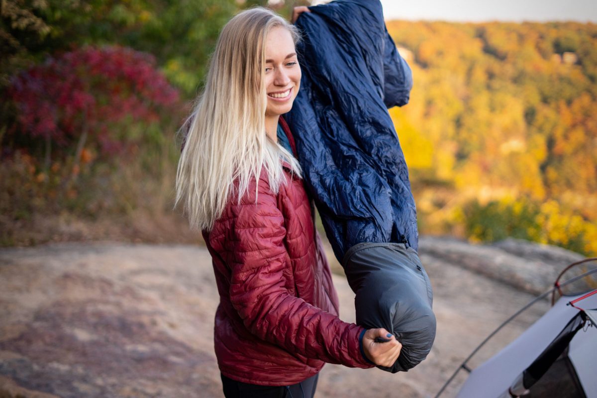 gearjunkie tester removes a sleeping bag from its stuff sack while backpacking and testing in Tennessee