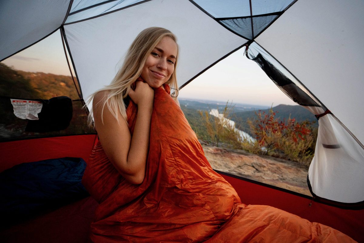 a gearjunkie tester wraps up in the enlightened equipment enigma quilt inside an msr backpacking tent