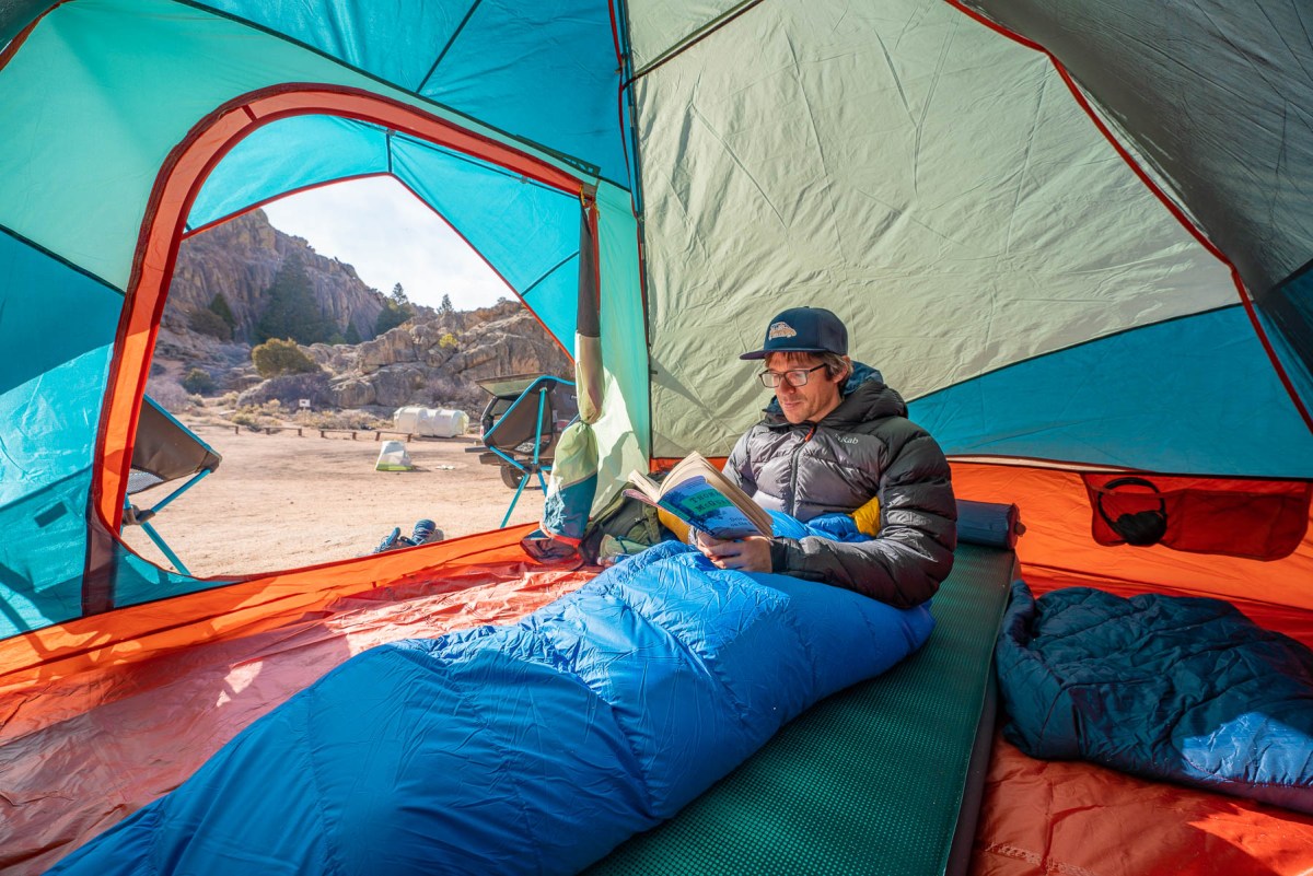 gearjunkie tester matt bento reads in a sleeping bag while laying on the nemo roamer backpacking sleeping pad