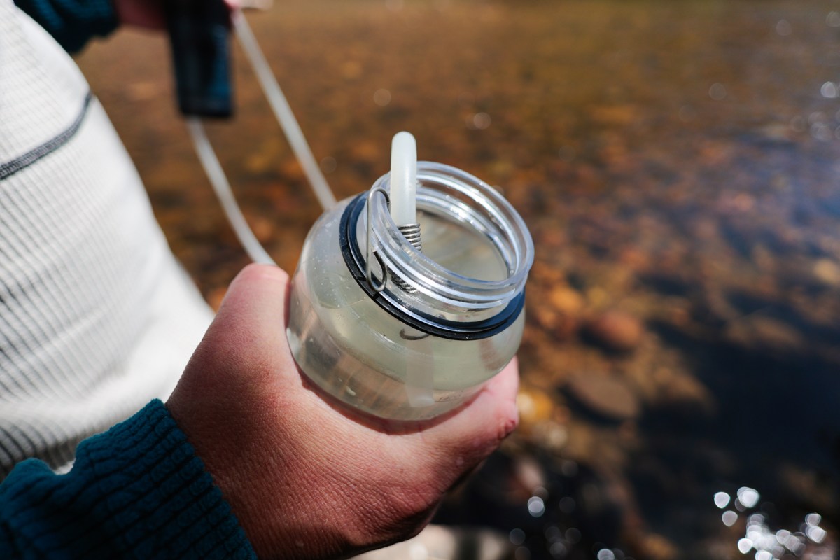 Close up of the bottle adapter attached while filtering water near the lake