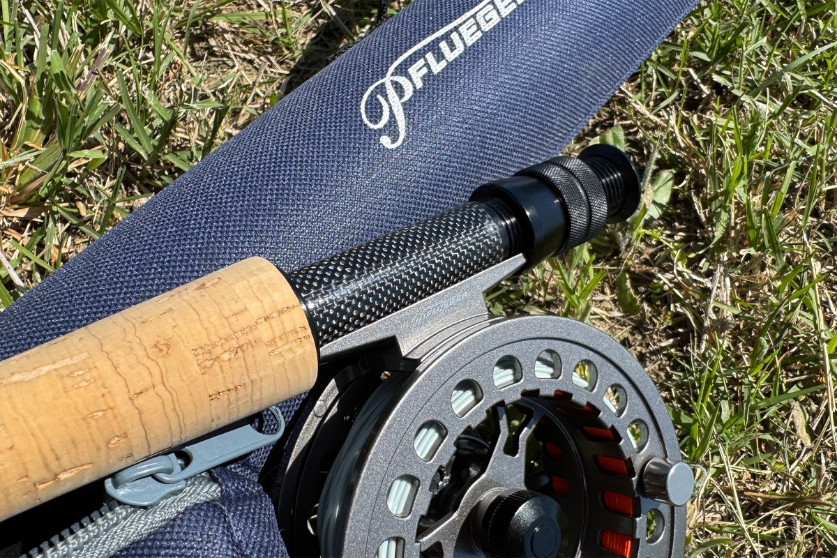 Close view of the Pflueger President XT reel, cork handle, and reel seat on the grass