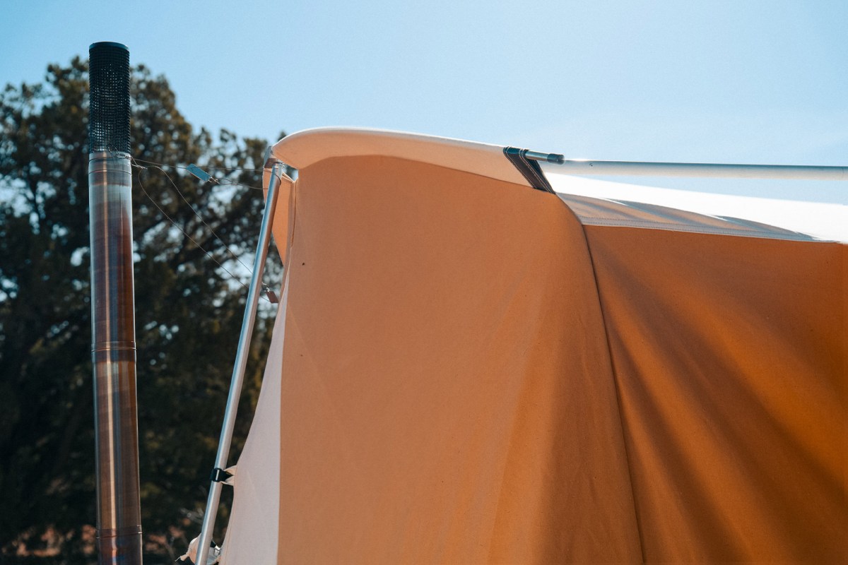 Stove pipe and spark arrestor beside the canvas tent roof