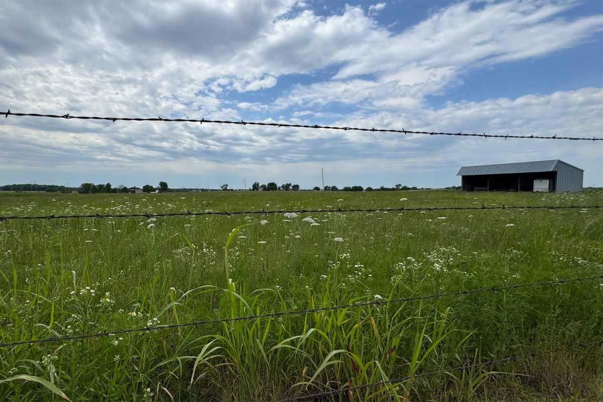 Open field behind barbed wire fencing used as a GPS fence testing area