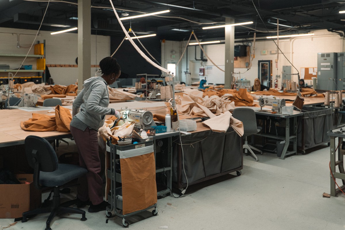 Workers sew and assemble canvas tent fabric inside the Springbar workshop