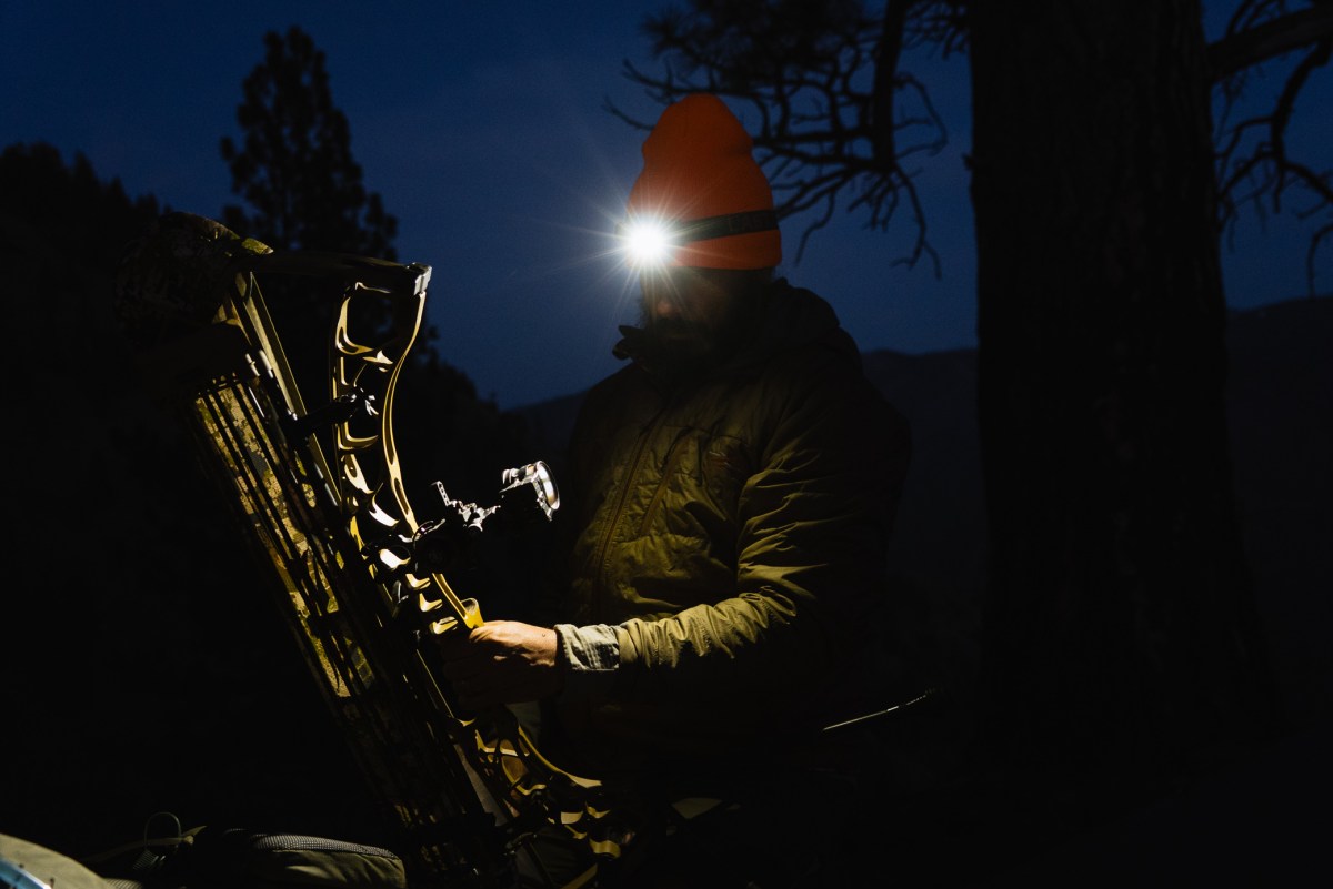 A hunter uses the Last Light headlamp while handling gear in the dark