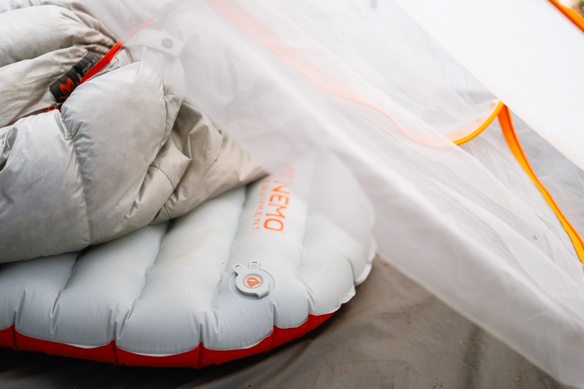 NEMO Tensor All-Season Sleeping Pad partially covered by a quilt inside a tent