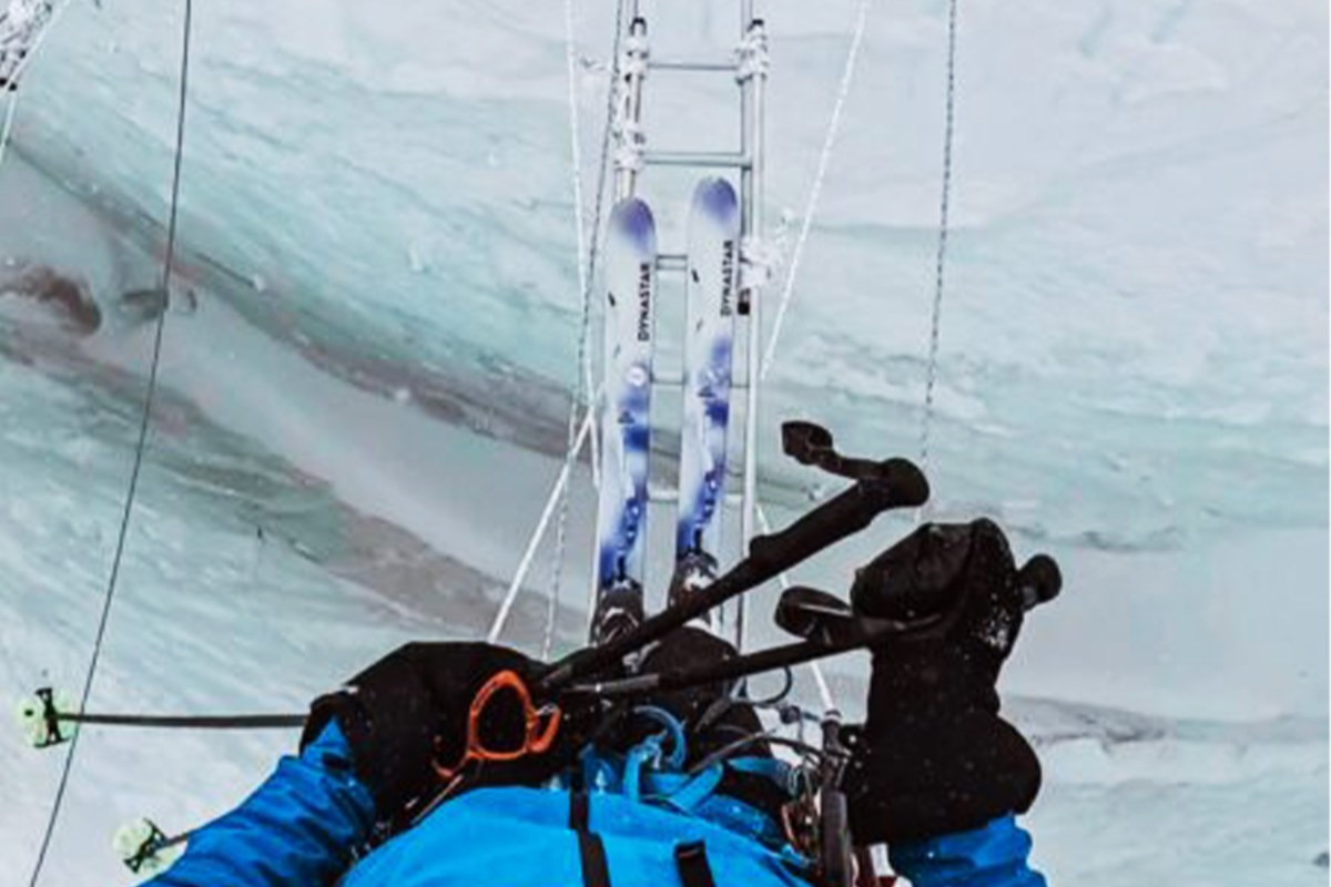Bartek Ziemski crossing a ladder over a crevasse