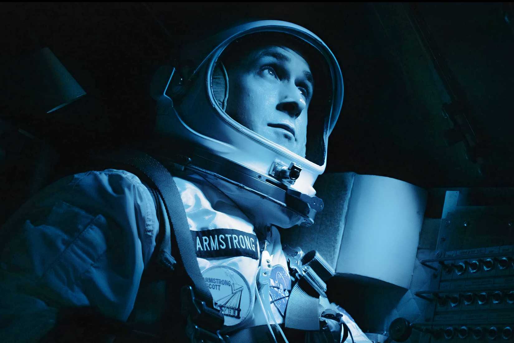 Neil Armstrong sits in a spacecraft wearing a NASA flight suit in First Man.