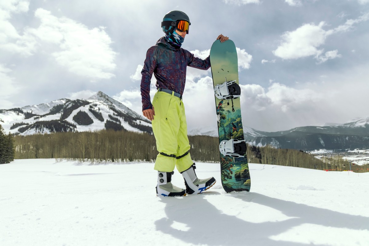 Burton snowboard boots positioned next to snowboard with graphic base
