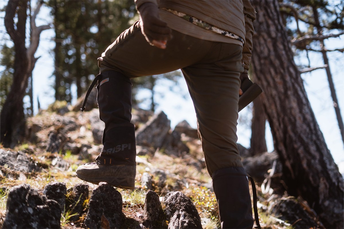 Hunter wearing Crispi boots with black gaiters while climbing through a rocky forest