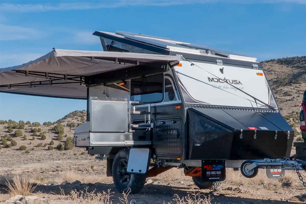 MDC XT9 camper trailer with awning and pop-up roof opened in a desert campsite