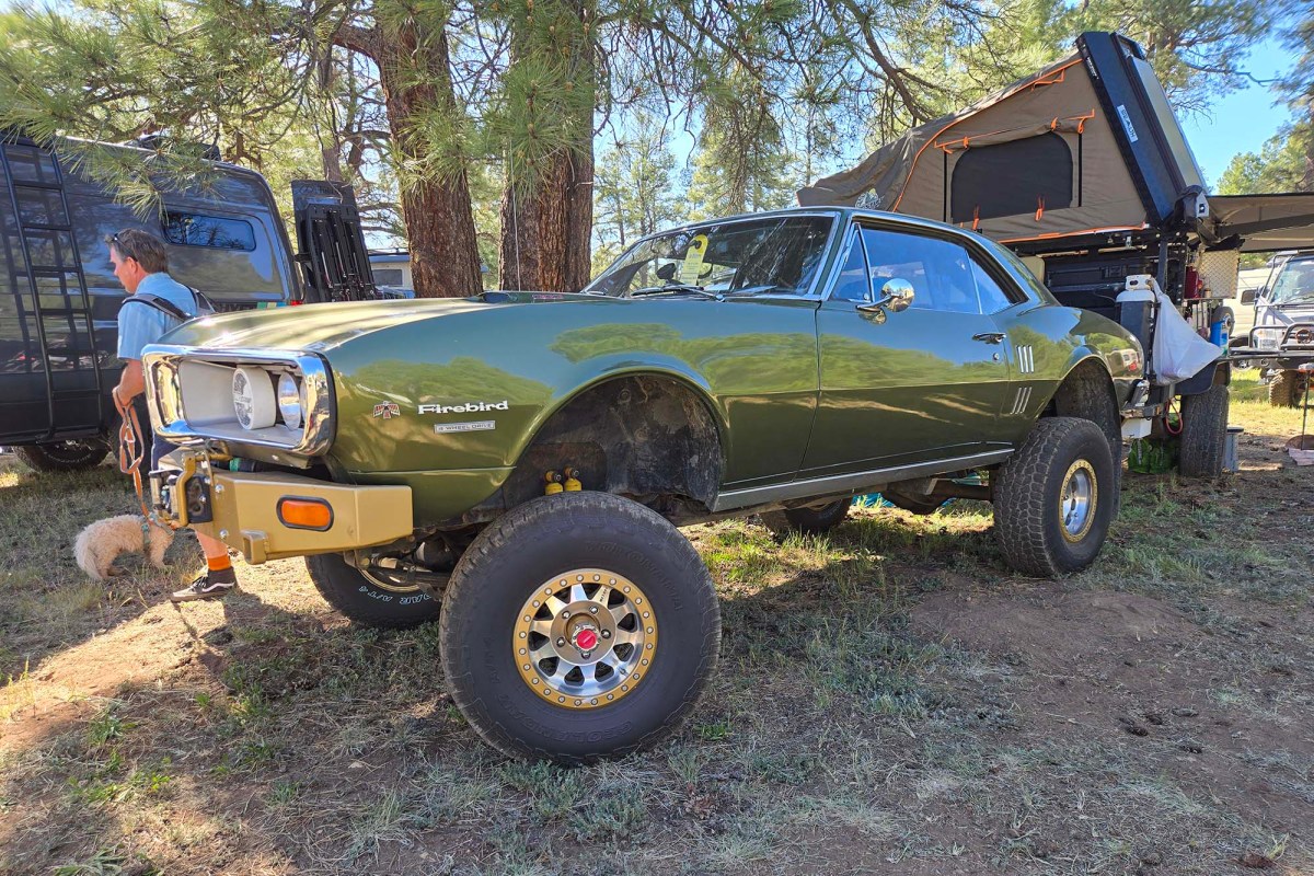 Green Pontiac Firebird with lifted suspension and large off-road tires