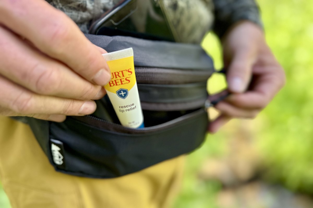 placing the lip balm into a fanny pack