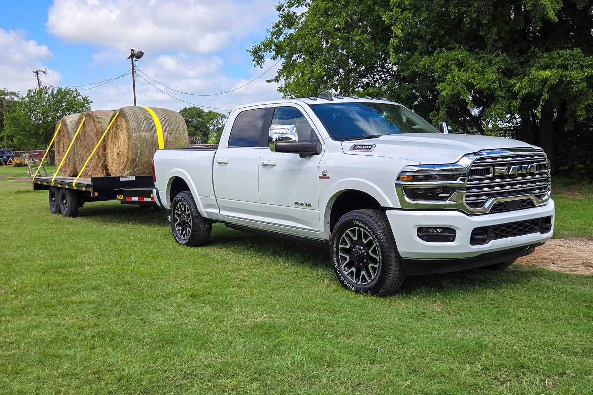 White Ram 2500 towing hay bales on a flatbed trailer