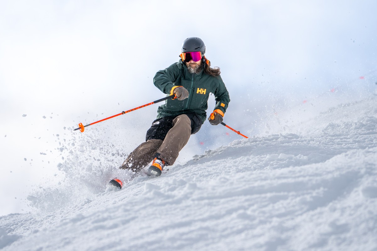Skier wearing the Ridge Infinity Jacket 2.0 makes a turn through soft snow