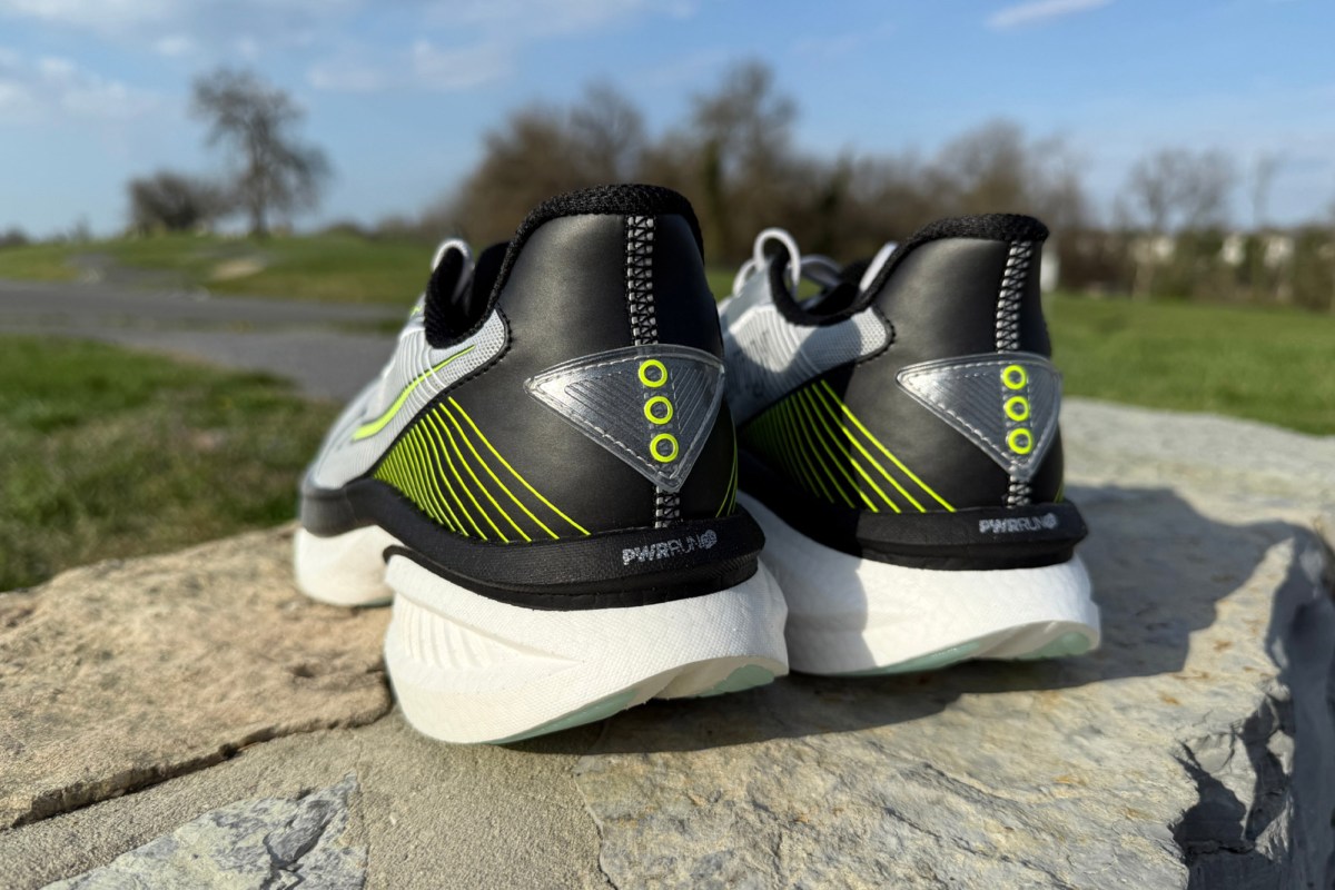 Rear view of gray running shoes with black heels on a stone wall