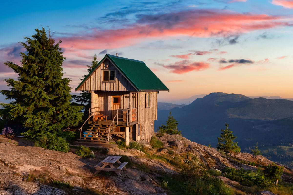 hut on mountainside with sunset