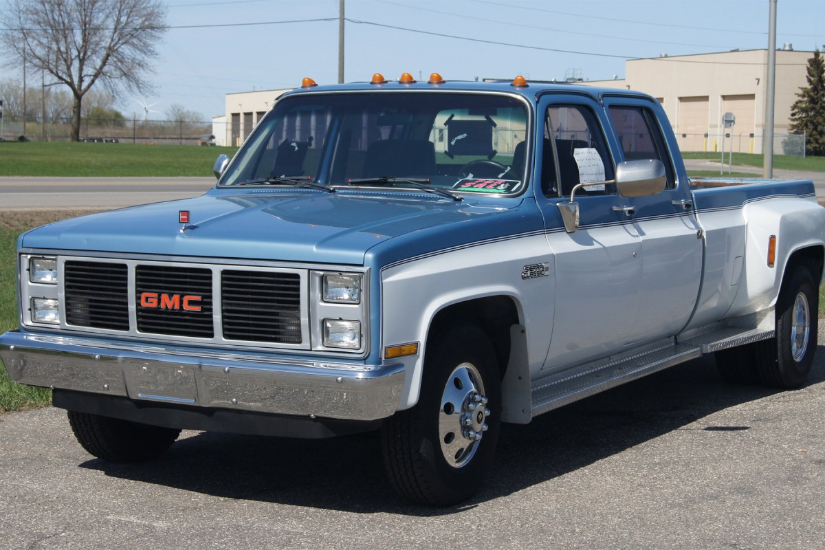 Blue and white GMC Sierra Classic dually pickup parked outside