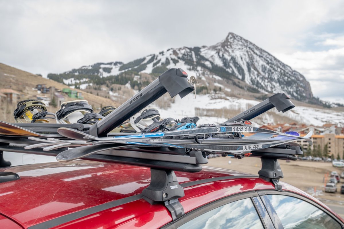 Two Malone ski carriers shown in the open, angled position against a mountain backdrop.