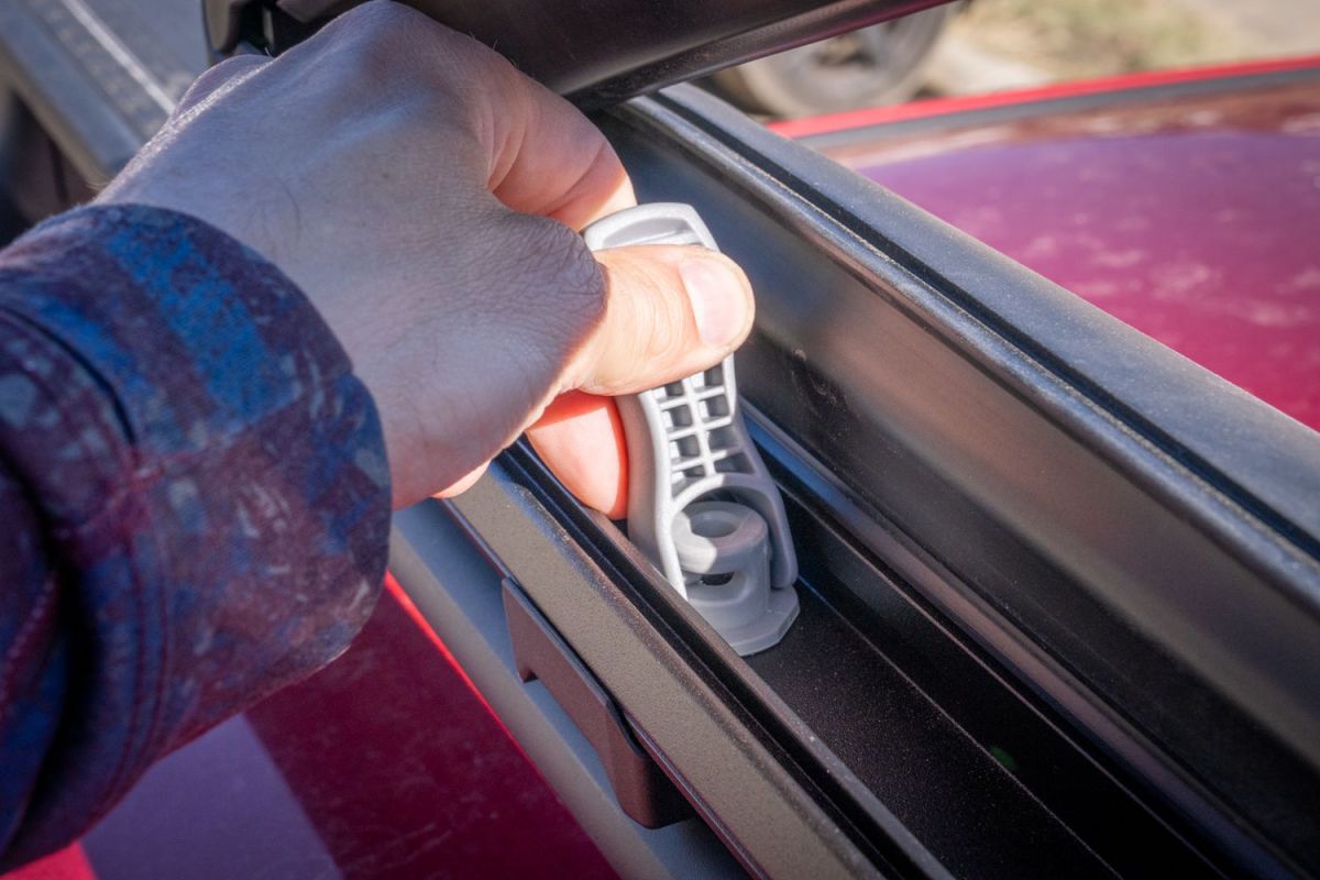 Hand lifting rubber strip on Thule Snowpack ski rack