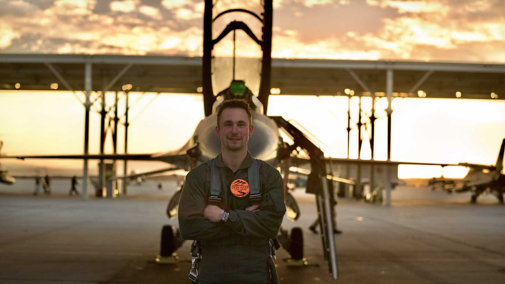 Louis Skupien stands in flight gear near an F-16D at Edwards Air Force Base after his documentary flight.